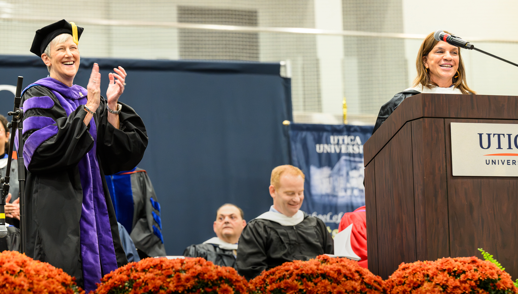 President Nesbitt stands and claps on stage at her Presidential Inauguration.